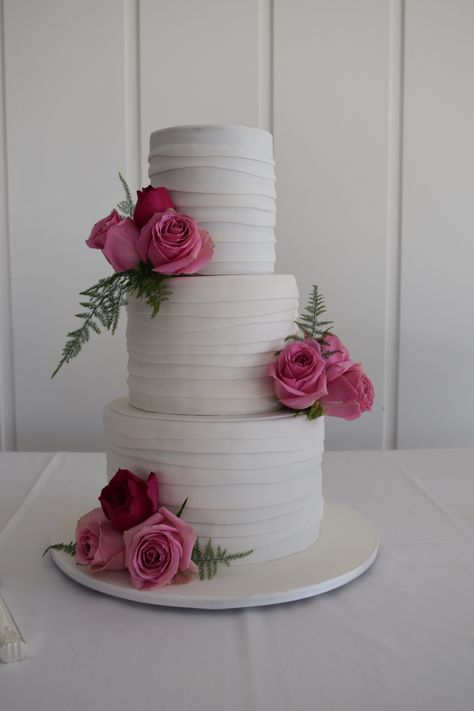 Three tier whit wedding cake with fresh flowers. By Vanilla Rose Cakery Three Layer Cake Design, White 3 Layer Wedding Cake, Pink And White Wedding Cake 2 Tier, White Wedding Cake Red Roses, Cake Roses, Rose Petal Cake, 3 Tier Pink And White Wedding Cake, Red Rose Wedding Cake 2 Tier, Birthday Cake Roses