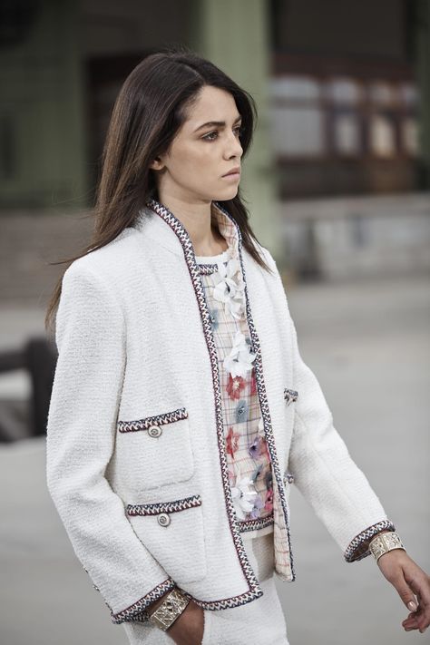 THE ICONIC WHITE JACKET  For Cruise 2019/20, CHANEL explores new possibilities for the CHANEL tweed suit, the House's timeless icon and the epitome of the savoir-faire in its ateliers housed on the rue Cambon. Whether with a rounded, wing or standup collar, elongated with a miniskirt or A-line skirt, the jacket takes on the shades of white in pure hues, embellished with jewelled buttons and trim reprising CHANEL's signature metallic chain. Its silk chiffon lining incorporates a delicate chain to Chanel Jacket Street Style, Chanel Street Style, The Ambassadors, Tweed Fashion, Chanel Tweed Jacket, Chanel Suit, Chanel White, Tweed Suit, Mode Chanel