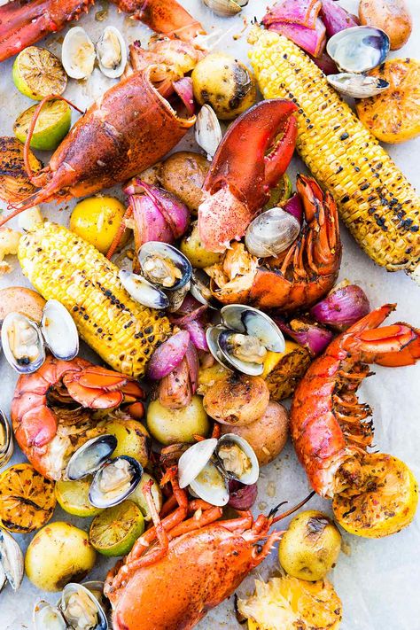 New England Clambake made with clams, lobster, Old Bay, sweet corn, and potatoes, is a summer classic. Easy to make at home. Clambake Recipe, Pescetarian Recipes, Lobster Bake, Boiled Food, Clam Bake, Lobster Recipes, Beach Meals, Seafood Boil, Food Words