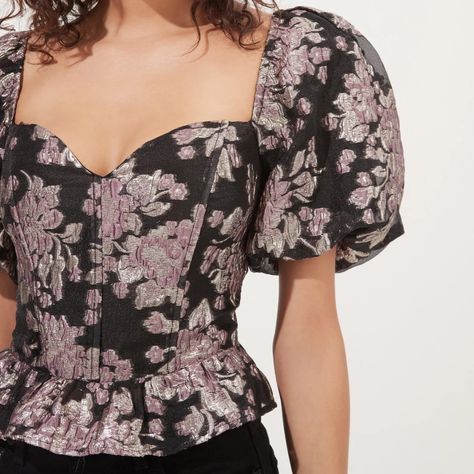 The Sidney Top Features A Statement Floral Print That Starts With A Sweetheart Neckline And Leads To A Corset-Style Bodice With Boning. Peplum Hem. Short Puff Sleeves. Smocked Back. Zipper Closure At Side Seam Brocade Fabric With Metallic Detail Throughout Size: Large Style: Sidney Floral Puff Sleeve Corset Top Color: Black Lilac Floral Style #: Act16914 Self: 100% Polyester Lining: 97% Polyester / 3% Elastane Pit To Pit: 17.5” Shoulder To Hem: 20” Corset, Brocade, Metallic, Floral, Puff, Peplum, Modern, Flattering, Statement, Dainty, Whimsical, Plazacore, Classy, Cocktail, Chic, Edgy, Festival, Glam, Glamorous, Glitz, Feminine, Flirty, Eras Tour, Taylor Swift, Fancy, Delicate, Fri Puff Sleeve Corset Top, Corset Blouse, Women Floral Blouse, Leather Pant, Cutout Bodysuit, Astr The Label, Indian Designer Outfits, Peplum Hem, Corset Style