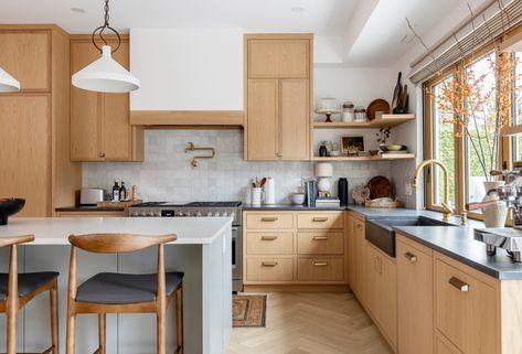 This kitchen was redesigned with hosting in mind: featuring a modern L-shaped layout, seamless oak cabinetry, brass fixtures, black quartz counters, and a sleek pass-through window—perfect for effortless summer entertaining. ☀️⁠ ⁠ ⁠ #KennedyConstruction #KCW23rd⁠ Designer |⁠ @oliversimondesign ⁠ Photographer | @pineconecamp  #kitchen #vancouverluxuryhomes #interiors #sustainableliving #modern #custombuilders #dreambuilders #functionalspaces #northshorebuilders #northvancouverhomes Kitchen Interior Window, U Shaped Kitchen Interior, Black Farmhouse Sink, Black Quartz Countertops, Pass Through Window, W Pictures, Interior Window, Folding Glass Doors, Weathered Furniture