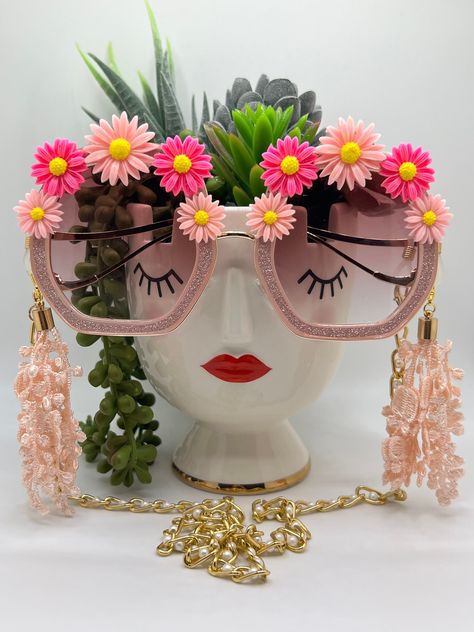 Hues of colorful daisies surround these polygon, glittering lenses, and are accompanied by an adjustable and removable eyewear chain and removable tassels. Featuring bold, fashion-forward designs, these glamorous sunglasses are perfect for making an entrance at any special occasion. Embellished and colorful, these fun and inspiring sunglasses will make sure you stand out in a crowd. Ideal for bachelorette parties, Vegas trips, weddings, birthdays, and more - Roaring Sunnies are the perfect acces Embellished Sunglasses Diy, Quirky Sunglasses, Glamorous Sunglasses, Crazy Sunglasses, Blossom Costumes, Diy Sunglasses, Colorful Daisies, Embellished Sunglasses, Cowgirl Bachelorette Parties