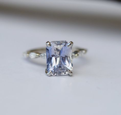 One of a kind and unique engagement ring created by Eidelprecious. Absolutely amazing sapphire ring! It features a natural emerald cut sapphire sparkling and clean. The sapphire changes color from ice blue to silver grey depending on the lightening. This stone is eye clean and very sparkling. Sapphire Emerald Cut Ring, Light Blue Sapphire Engagement Ring, Emerald Cut Ring, Light Blue Sapphire, Blue Sapphire Engagement Ring, Wedding Studs, Future Engagement Rings, Classic Engagement, Ring Sapphire