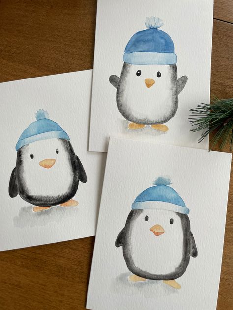 Description: Bring a touch of charm to your holiday greetings with this adorable winter penguin watercolor card! This 5x7 card features a hand-painted watercolor illustration of a cute penguin wearing a cozy blue hat, making it perfect for spreading warmth and joy during the holidays. Key Features: ❄️Original Watercolor Art: Each card showcases a unique, hand-painted winter penguin, ensuring that no two cards are exactly alike. ❄️Perfect for the Holidays: Ideal for Christmas, winter celebrations, or any festive occasion. ❄️Blank Inside: Plenty of space for your personalized message, making it suitable for various occasions. ❄️Quality Materials: Made with premium Strathmore watercolor paper for a beautiful and lasting finish. ❄️ White Envelope Included: Comes with a high-quality white envel Easy Christmas Watercolour Painting, Painted Penguins On Wood, Christmas Cards Handmade Watercolor Simple, Christmas Card Designs Watercolour, Watercolor Holiday Art, Easy Holiday Watercolor, Easy Watercolor Holiday Card, Simple Painted Christmas Cards, Watercolor Painting For Boyfriend