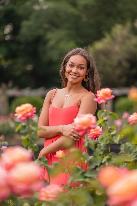 Senior portrait of mixed-race teen girl smiling and posing behind a rose bush. Pink and yellow roses are out of focus in the foreground surrounding her. Garden Senior Pictures, Flower Field Senior Pictures, Spring Picture Ideas, Field Senior Pictures, Senior Pictures Locations, Prom Photography Poses, Cute Senior Pictures, Senior Photoshoot Poses, Senior Photography Poses