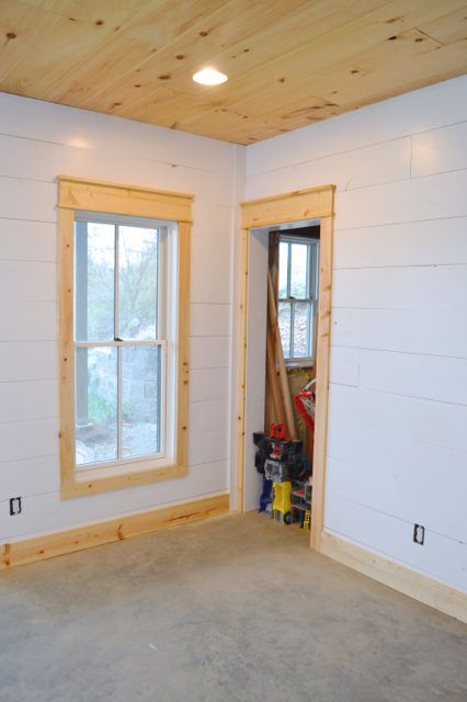 installing DIY shiplap walls and farmhouse trim from wood flooring Simple Wood Window Trim, Farmhouse Living Room Trim, Natural Wood Trim Windows, Window Trim No Sill, Natural Wood Window Trim, Simple Farmhouse Trim, Modern Farmhouse Interior Trim, Burnt Wood Trim, Natural Wood Baseboards