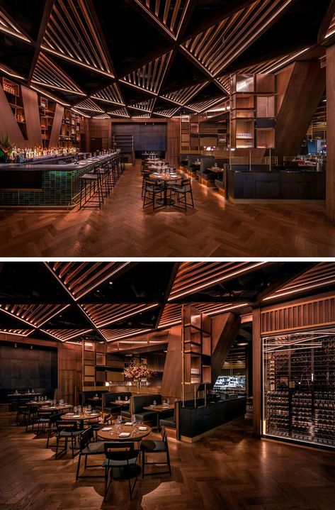 This modern restaurant's distinctive and massive structural joists divide the bar area from the main dining room. These angled columns& inspired the bar’s geometrical millwork and its triangular patterned wood trellis ceiling. #RestaurantDesign #ModernRestaurant #RestaurantInterior Bar Ceiling Lights, Pub Ceiling Design, Celing Roof Design For Restaurant, Triangular Ceiling Design, Back Bar Design Restaurant Modern, Restaurant Ceiling Design Modern, Bar Ceiling Design, Cafe Ceiling Design, Trellis Ceiling