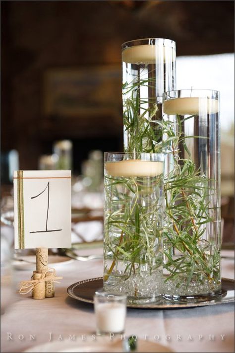 12 sets of clear glass vases, 3 per set (36 vases total). All vase openings are 3.5 inches in diameter. Each set contains one 10-inch tall vase, one 14-inch tall vase, and one 18-inch tall vase. We cut branches from the park and submerged them in water with a floating candle on top for an elegant and simple centerpiece.  I have silver chargers that the vases sit on that I will include if you're interested. I also have glass beads that you can put in the bottom of each base to hold a flower ... Clear Glass Cylinder Vases Decor Ideas, Candles In Clear Vases, 3 Glass Vase Centerpiece, Wedding Centerpieces Glass Vases, Tall Cylinder Vase Centerpiece, Cylinder Vases Wedding, Water Beads Centerpiece, Vases Decor Ideas, Floating Candle Centerpieces Wedding