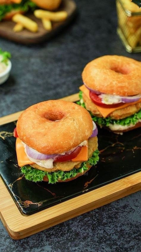 Yummilicious Donut buns with fried Burger Patties and Savory burger sauce is a perfect combo! Take the donut and cut it in half and spread the sauce made with Mayonnaise, Dijon Mustard with Honey, Ketchup, Hot Sauce and Lemon Juice on it, place the Burger Patty on it and garnish it with Onion Rings, Tomato Slices, Cheddar Slice, Lettuce and chopped cucumber pickles. Apply the sauce to the other half of the donut and place it on top. The Donut Burger is ready Doughnut Burger, Cheese Burger Recipe, Donut Burger, Crab Burger, Doughnut Bun, Cucumber Pickles, Donut Bun, Cheeseburger Recipe, Burger Patties