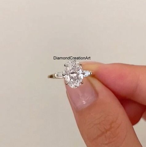 2.50 Ct Oval Cut Colorless Moissanite Ring, Side Tapered Baguette Three Stone Engagement Ring, Claw Prongs, Wedding Occasion Ring For Her Detail about stones Moissanite & Simulated Stone: ----------------------------- ➠Stone Shape : Oval, Tapered Baguette  ➠Stone Size : 10x7 MM, 4x3x2 MM ➠Weight: 2.92 TCW ➠Color: Colorless ➠Cut: Excellent ➠Clarity: VVS ✍This Listing's images are only for Imagin about this item. This is all our photography. If you place the order then the same item we can make it Oval Engagement Ring With Baguette Side Stones, Tapered Baguette Engagement Ring, Dream Proposal, Baguette Engagement Ring, Ring Three Stone, Ring Inspo, Three Stone Engagement Ring, Oval Engagement, Moissanite Diamond Rings