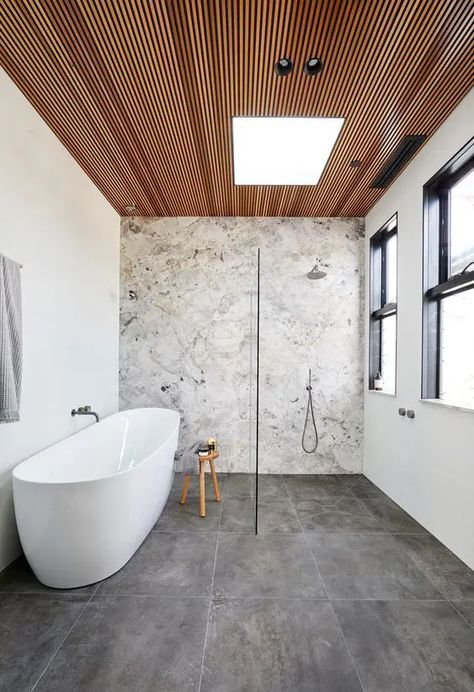 a contemporary bathroom with a stone accent wall, concrete tiles, a wood slab ceiling, neutral fixtures is chic Beautiful Tile Bathroom, Stone Feature Wall, Top Bathroom Design, Timber Ceiling, Wooden Ceiling, Bad Inspiration, Bathroom Modern, Tile Trends, Bathroom Ceiling