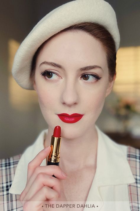 Close up of a woman's face who is holding a tube of red lipstick in front of her. 50s Lipstick, Revlon Red Lipstick, Revlon Love That Red Lipstick, Revlon Lipstick Shades, 1940s Lipstick, Vintage Red Lipstick, Revlon Certainly Red Lipstick, 1950s Red Lipstick, Revlon Lustrous Lipstick Swatch