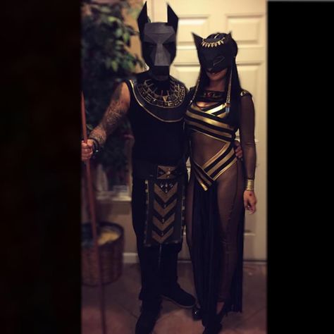 Couple Halloween costumes. Anubis and Bastet. Paper masks from Etsy. Egyptian Group Costume, Mummy Couple Costume Halloween, Anubis Halloween Costume, Egyptian Halloween Costume Couples, Egyptian Family Costumes, Bastet Goddess Costume, Cleopatra Halloween Costume Couple, Egyptian Couple Costume, Egyptian God Costume