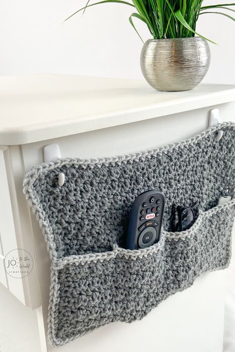 Running out of space on your night table? This easy, fast, free pattern (perfect for beginners) for a hanging remote caddy is a terrific storage idea. This organizer will hold your glasses, phones, pens, notepads and TV remote controls and keep your room organized and decluttered! And it makes a terrific crochet gift idea for men, women and friends.   For more crochet gift ideas, follow me! Crochet Gift Ideas, Crochet Organizer, Remote Control Holder, Remote Holder, Crochet Storage, Quick Crochet Patterns, Crochet Gift, Diy Magazine, Easy Stitch