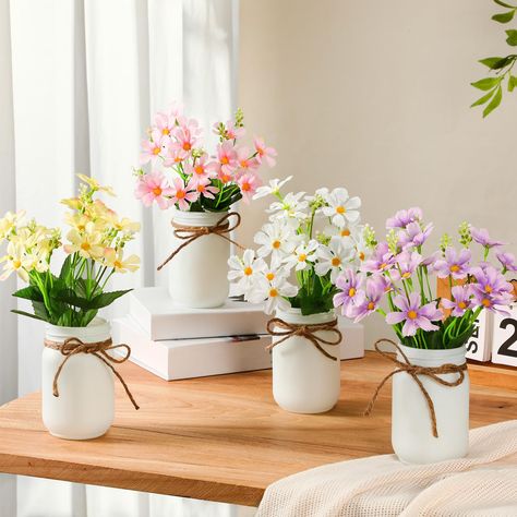 PRICES MAY VARY. Vibrant Potted Flowers: instantly brighten your home with our 4 different colors of artificial daisy flowers that are carefully arranged in charming white mason jars adorned with rustic twine; The flowers, characterized by their vivid and rich white, pink, yellow, and purple hues, fit seamlessly with any decor, bringing a splash of invigorating energy into any room Quality Craftsmanship: featuring lifelike flowers delicately crafted from quality materials, these faux flowers art Mason Jar Artificial Flower Arrangements, Artificial Flower Centerpieces, Centerpieces For Tables, Summer Table Decorations, Flower Branches, Small Flower Arrangements, Potted Flowers, Jar Centerpieces, Mason Jar Centerpieces