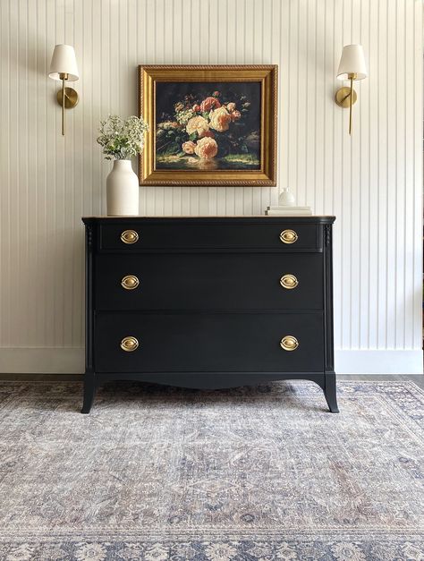 *DRESSER AVAILABLE!* This Hepplewhite antique dresser has a delightful energy and a modern organic essence! If you love more transitional or a mix of styles in your home while keeping a traditional undertone then this vintage dresser is for you! This chest of drawers has it all - a smooth matte black exterior, the quintessential Hepplewhite oval brassy gold pulls on each drawer and offers plenty of storage. What makes this dresser stand out is like something from a country farmhouse or an RH catalogue is the naturally gorgeous driftwood/primitive raw wood top.  A dark wax was added to the raw wood top to seal for durability, add a weathered look and be able to be a piece or table top in a high traffic area. Use this piece in a bedroom as a dresser, as a nursery dresser/chest, an entryway c Black Dresser Gold Mirror, Dark Brown Painted Dresser, Black Furniture Decor Ideas, Antique Commode Makeover, Antique Black Dresser, Antique Refurbished Furniture, Decorated Dresser Top, Black And Wood Dresser Makeover, Antique Wood Dresser