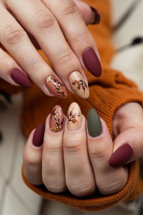 Embrace the warmth of autumn with these delightful oval fall nail ideas. Picture your nails adorned in rich burgundy and golden accents, perfectly capturing the essence of the season. The oval shape adds elegance, showcasing intricate leaf designs that evoke the beauty of falling leaves. This nail style is not only trendy but also a fabulous way to celebrate the cozy vibes of fall. Tap into your creativity and let your nails reflect the charm of the season! Oval Nails Ideas Fall, Thanksgiving Nails Acrylic Oval, Fall Nail Designs Floral, Fall Leaves Manicure, Fall Almond Nails Ideas Green, Oval Nail Ideas Fall, Fall Acrylic Nails Almond Shape, Autumn Nails With Leaves, Almond Shaped Fall Nail Designs