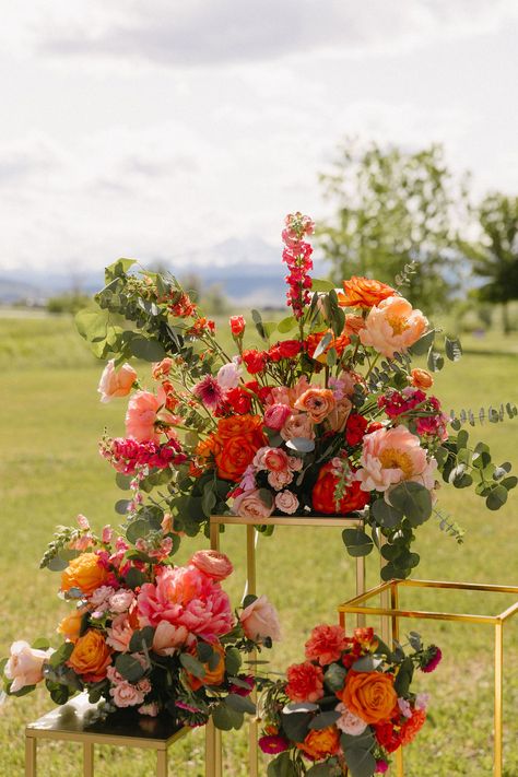 Colorful Wedding Florals at Yellowstone Ranch| Colorado Wedding Photographer | Just love these colorful wedding florals with pops of orange and pink! These were unique luxury wedding florals that really popped against the mountain ceremony backdrop at Yellowstone Ranch. Get inspired by luxury wedding florals, outdoor ceremony decorations, colorful wedding schemes, Colorado mountain wedding venues, and more. Book Logan as your Colorado wedding photographer at mrsferreephotography.com!