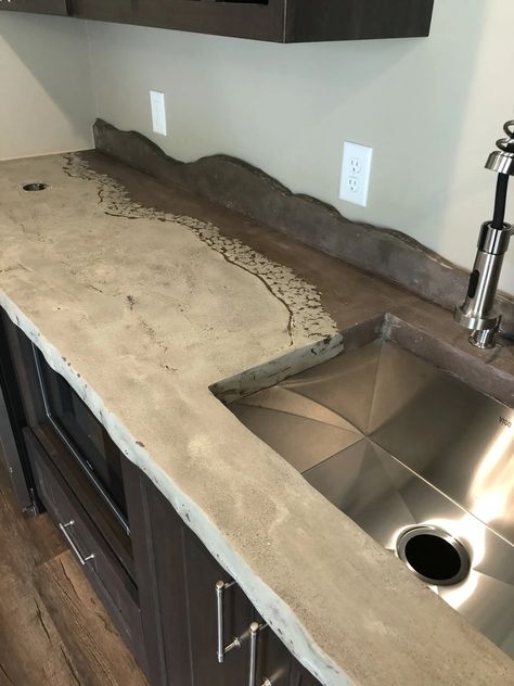 Mountainous backsplashes are a breeze with concrete! These countertops also have a live edge. With endless options for color and design you should choose concrete! #ConcreteCountertops, #CustomDesigns, #KitchenRemodel, #BespokeCountertops, #ModernConcrete, #UniqueSurfaces, #InnovativeDesign, #HomeRenovation, #InteriorDesign, Stylish Countertops, Creative Concrete, Handcrafted Surfaces, Contemporary Decor, bar tops, concrete bar Dark Concrete Countertops, Colored Concrete Countertops, Feather Finish Concrete Countertops, Concrete Bar Top, Unique Countertops, Concrete Edging, Concrete Bar, Bar Tops, Wood And Concrete