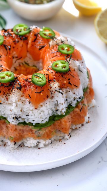 Nadia Aidi on Instagram: "Sushi Bundt Cake 😍 I understand that it isn’t traditional by any means but it is a super popular dish in my hometown in Mexico (Obregon, Son)…google ‘Rosca De Sushi’ and you’ll see 😉. So typically it is done with surimi (imitation crab) but I prefer the salmon! Tip: cook your rice in a rice cooker the night before. Way better results imo. I used a 6-cup bundt pan. Ingredients: * 1.5 cup uncooked calrose rice (made in rice cooker or cooked to package instructions). * 3 tbsp + 2 tsp rice vinegar. * 1 tbsp sugar. * 3 tbsp black and toasted sesame seeds. * pinch of salt. * 1 lb sushi grade salmon. * 1/4 cup japanese mayo. * 2 tbsp sriracha. * 1 tsp tamari + more for the sauce. * 1 serrano (finely chopped) + more for topping. * 3 scallions (chopped, separate white a Sushi Bundt Cake, Sushi Grade Salmon, Sushi Stacks, Calrose Rice, Rice In A Rice Cooker, Japanese Mayo, Sushi Cake, Toasted Sesame Seeds, Bundt Pan