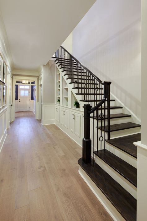 There are two design choices that really stand out in this picture. The first is the wonderful contrast between the light hardwood flooring used in the hallway and the dark hardwood flooring used on the stairs. The second is the handrail style used. They work together to bring a truly unique piece together. Hardwood Floor Stairs, Moulding Styles, Stained Staircase, Dramatic Entryway, Wood Floor Stairs, Interior Moulding, Stairs Colours, Transitional Staircase, Staircase Styles