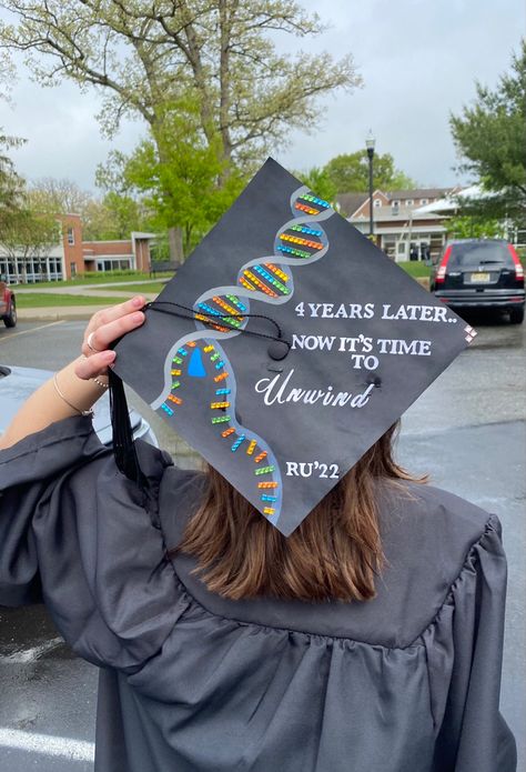 Graduation cap with a DNA helix unwinding by a DNA helicase. To the right of the DNA strand says “4 years later.. Now it’s time to unwind” Bachelors In Biology Cap, Graduation Cap Designs College Biology, Science Graduation Cap Designs, Cap Decoration Graduation Biology, Grad Cap Ideas Biology, Graduation Cap Designs Exercise Science, Chemistry Graduation Cap Ideas, Biology Graduation Party Ideas, Biology Major Graduation Cap