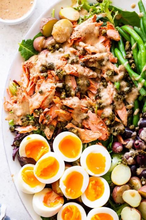 A delicious variation on the classic tuna Niçoise salad, this version includes tender salmon, crispy tender green beans, hearty potatoes and a delicious dressing that takes the salad to the next level. Paleo with a Whole30 option, this salad is sure to become a new favorite. #paleo #whole30 #cleaneating #salad #salmon Salmon Crispy, Salmon Nicoise Salad, Salad Salmon, Tuna Nicoise Salad, Paleo Running Momma, Hot Bacon Dressing, Paleo Salmon, Light Cooking, Parties Food