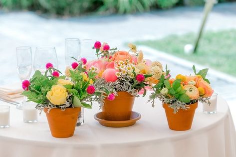 Colorful summertime floral centerpieces - pink, orange, and yellow flowers in terracotta pots. Willowdale Estate, a weddings and events venue north of Boston, Massachusetts. WillowdaleEstate.com Terracotta Pots Tablescape, Terracotta Pot Centerpiece, Pink And Orange Flower Centerpieces, Potted Wildflower Centerpieces, Terracotta Pots Wedding, Potted Centerpieces, Pink And Orange Floral Centerpieces, Yellow Orange Pink Wedding, Luncheon Centerpieces