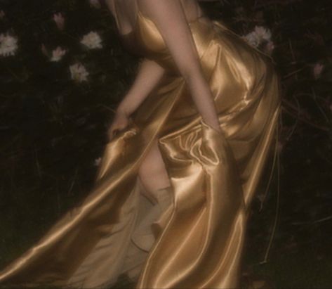 A aesthetic picture of a flowing golden gown/dress. In the night atmosphere the colors are blurry yet vibrant and clear. The dress is pictured during a motion which makes the picture look alive. It has similarities to an Victorian dress like they are drawn in oil paintings Gold Aesthetic Dress, Gold Dress Short Aesthetic, Golden Dress Aesthetic, Ethereal Gold Aesthetic, Brunette Gold Aesthetic, Gold Dress Aesthetic Royal, Dark Gold Aesthetic Royal, Dress Night, Dress Photography