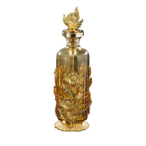 A stunning combination of brilliance and clarity, this elegant amber-hued, mouth-blown crystal bottle will contain your favorite eau de parfum, while adding a glamorous touch to any vanity table. Enriched with hand-engraved vertical wedges, the bottle (200ml) is encased in an ornate frame of charming daisies made of lost wax casting bronze with mirror-polished 24k gold plating. Delicate daisies also embellish the gold-rimmed stopper, complete with internal applicator. Available also in clear cry Daisy Perfume, Jasmine Perfume, Antique Perfume Bottle, Perfume Bottle Design, Pretty Perfume Bottles, Amber Crystal, Beautiful Perfume Bottle, Antique Perfume Bottles, Perfume Design