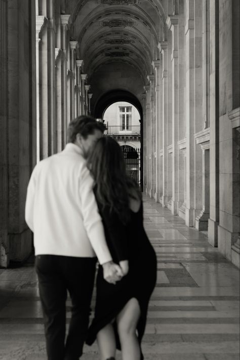 A couple walking down a beautiful archway at the Louvre in Paris, France. Paris Cafe Couple Photoshoot, Louvre Engagement Photos, Couples Photos Paris, Parisian Couple Aesthetic, Couple Photos In Paris, Madrid Couple Photography, Engagement Photos In Paris, Paris Photo Poses, Couple Stairs Photography