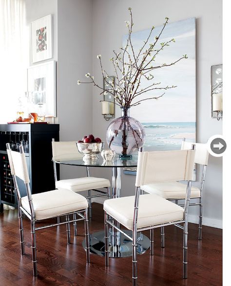 Dining room  Lindsay took advantage of a small nook in the main living space and created an elegant dining area by incorporating glass and metal furniture with clean lines. The round dining table ensures ease of flow, while the light, airy quality of the chairs makes them less obtrusive in the open-concept layout. Round Glass Dining Room Table, Glass Table Living Room, Glass Dining Room Table, Kitchen Table Settings, Home Goods Decor, Glass Dining Table, Livingroom Layout, Elegant Dining, Metal Furniture