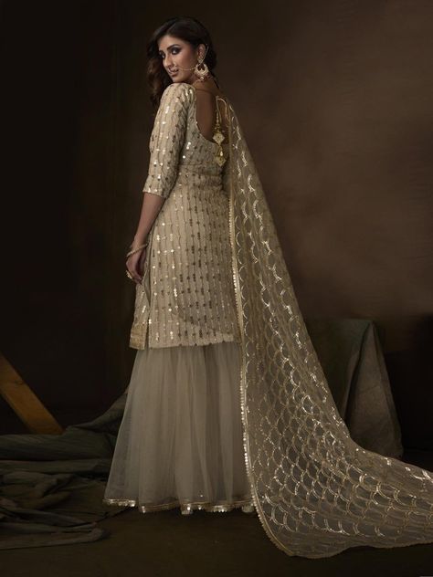 Buy fantastic cream net embroidered partywear sharara suit online for upcoming events from Inddus. This elegant set comprises a net sharara with matching net dupatta, crepe inner and net bottom. Punjabi Clothes, Sharara Design, Designer Sharara Suits, Punjabi Dresses, Gharara Suits, Sharara Suit, Punjabi Suit, Indian Suits, Pakistani Suits