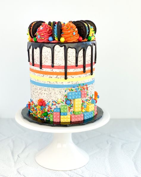 Celebration oreo cake for LEGO lovers complete with lego candies and all the colors! Lego Drip Cake, Double Drip Cake, Lego Chocolate Cake, Striped Birthday Cake, Rainbow Cake With Candy On Top, Lego Cake Ideas Buttercream, Holiday Donuts, Double Barrel Cake, Roblox Birthday Cake