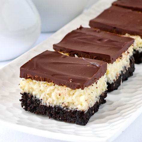 Coconut Bounty Cookie Bars. A super easy cookie bar with a chocolate cookie crumb base and a sweet coconut centre, all topped with a luscious chocolate layer. Very freezer friendly too. #cookiebars #cookierecipes #christmascookies #freezercookies #christmasbaking #holidaycookies Magic Stars Millionaire Cookie Bars, Coconut Bounty Cookie Bars, Coconut Brownies Recipe, Xmas Bars And Squares, Coconut Cookie, Dessert Squares, Rock Recipes, Coconut Desserts, Coconut Bars