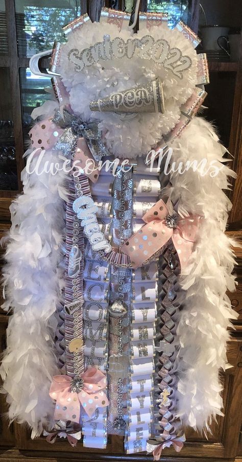 A Triple Deluxe Homecoming Mum in pink, white, and silver. Located in Arlington, TX. Creating custom Homecoming Mums for the DFW Metroplex since 2007. Senior Mums Homecoming White And Light Purple, Pink And Silver Homecoming Mum, Pink And White Mums Hoco, Big Mums Homecoming, Pink And White Mum, Senior Year Mums, Pink Mums, Mums Homecoming Senior, Pink Mums Homecoming