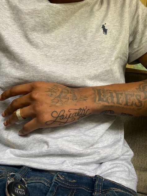 Loyalty Arm Tattoo Men, Loyalty Tattoo On Hand, Writing Hand Tattoos For Guys, Loyalty Over Money Tattoo, Hand Tattoos On The Side, Small Mens Hand Tattoo, Aesthetic Black Tattoo, Loyalty Hand Tattoos For Guys, Loyalty Arm Tattoo