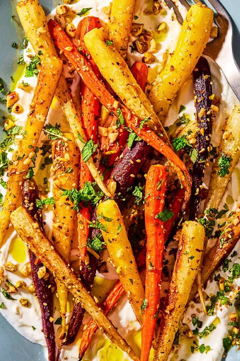 A close up photo of roasted rainbow carrots with with dukkah, mint and a garlicky yogurt sauce on a serving platter. Greek Roasted Carrots, Greek Carrots Recipe, Greek Carrot Recipes, Roasted Carrots Yogurt Sauce, Carrots With Yogurt Sauce, Greek Carrots, Roasted Carrots With Yogurt Sauce, Carrot Recipes Side Dishes, Greek Vegetables