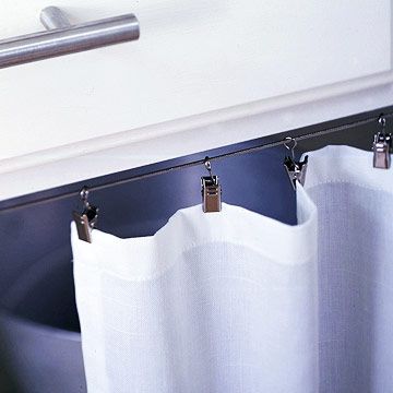 Base Cabinet Detail  -- A steel cable and clip-on rings make the curtain easy to install.    - an idea for the office? How To Hang Cabinet Curtains, Cover Cabinet Doors, Curtain Detail, Sew Apron, Cabinet Curtains, Sink Curtain, Cabinet Curtain, Cabinet Detail, Drapery Rings