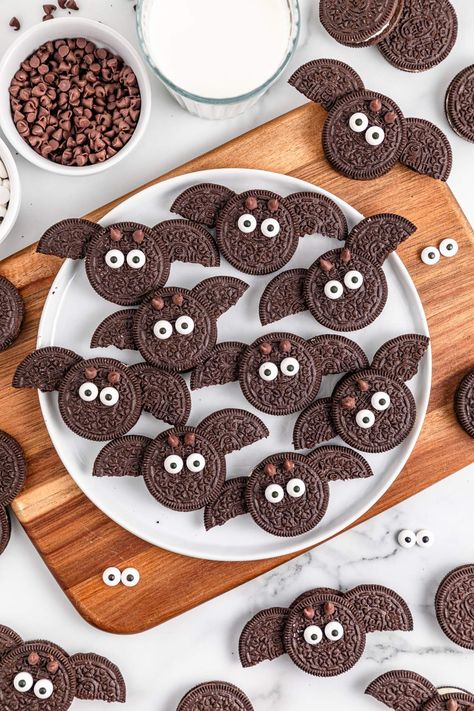 Just look at these adorable little Halloween themed snacks. They're bats and they're so simple to make. All you need for this fun project is Oreo cookies, some chocolate chips and candy eyeballs. With just those ingredients and a little time you can make these gorgeous snacks which are nearly TOO cute to eat! You can make a bigger batch too, since these keep for up to a week. Every time you see one of these cute little Halloween bat Oreos you're going to smile because they're fun and so CUTE! Bat Brownies For Halloween, Halloween Oreo Bat Cookies, Halloween Cones Treats, Halloween Bat Food Ideas, Bat Cookies Halloween, Oreo Bat Cookies, Oreo Halloween Cookies, Bat Oreos, Bat Desserts