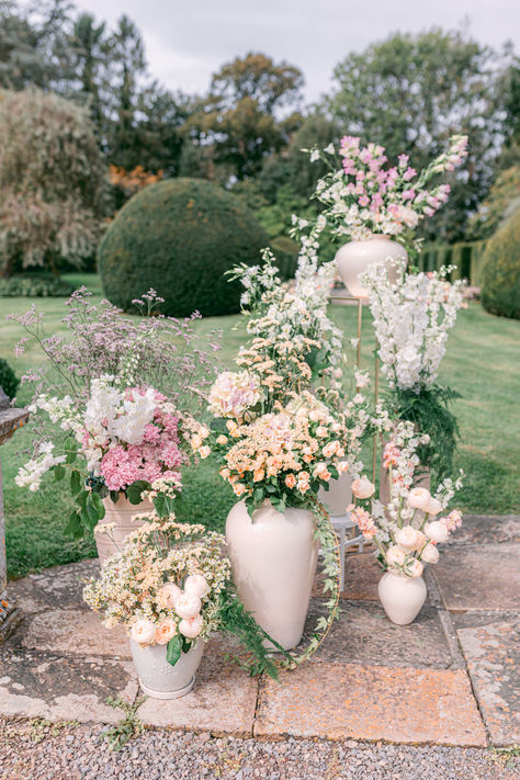 Modern Ceramic Vase Ceremony Backdrop #ceramicvase #weddingvases #weddingcenterpieces #weddingflowers #floralarrangements Modern Urn Flower Arrangements, Large White Vase With Flowers, Wedding Ceremony Vases, Wedding Ceremony Urn Arrangements, Cross Wedding Flowers, Romantic Garden Wedding Ceremony, Wedding Urns Ceremony, Wedding Flower Vases, Grounded Florals Wedding Ceremony