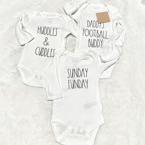 Rae Dunn White Football Onesies With Black Lettering. "Daddy's Football Buddy", "Sunday Funday" And "Huddles & Cuddles". Size 6-9 Mos. Baby Christmas Onesie, Fall Bodysuit, Baby 12 Months, Christmas Onesie, White Onesie, Baby In Pumpkin, Snap Fasteners, Long Sleeve Onesie, Baby One Piece