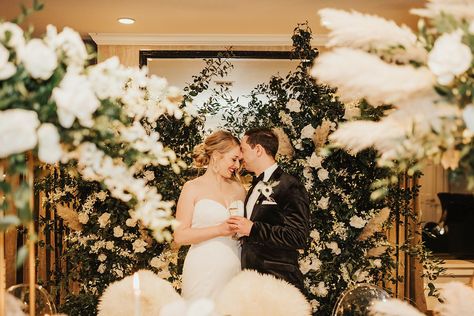 Caitlin Schlosser and Marco Puccia wanted to do something different for their wedding celebration. They decided to have a microceremony with 20 of their closest friends and family, followed by a larger reception one month later. The intimate, glamorous nuptials took place at the top of Hotel Sorrento in Seattle, which was built in 1909. The couple decorated the vintage boutique hotel with a color palette of black and gold. A luxe wedding arch with white flowers and greenery framed the ceremony s Wedding Arch With White Flowers, Arch With White Flowers, Flower Wedding Arch, Couples Decor, Do Something Different, Tall Centerpieces, Luxe Wedding, Reception Party, Cocktail Reception