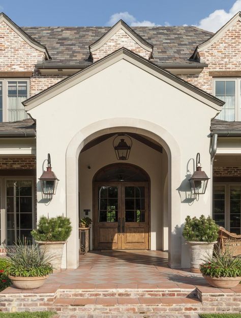 The gracious entrance features a stylized portico with flanking verandas. Saltillo Mexican tile is the perfect complement to the brick and stucco facade. Exterior Stucco, Front Porch Remodel, Brick Wall Decor, French Country Ideas, Stucco Colors, Porch Paint, Porch Remodel, Brick Ranch, Stucco Exterior