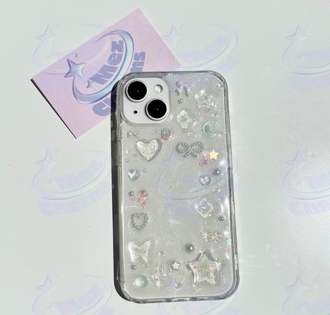 This is a one-of-a-kind glossy resin phone case made with a variety of charms and beads. The base resin layer has a slight white glitter sheen. Pearls, glass beads, glitter charms in bows, stars, hearts, flowers, and butterflies adorn this unique case. The inspiration is the maximalism, glitz and glamour of the late 90s and early 2000s (y2k-era). 𖦹 Please note: these cases are handmade and made-to-order. This means that each case will naturally have slight variations. The charms will be distributed slightly differently on different sized phone cases. Slight charm variation is typical due to what charms I have in my inventory. 𖦹 Processing time is about 2-3 days.  𖦹 If you cannot find your phone in the selection, feel free to message me and I will see if I can make a phone case for you. Clear Iphone Case Ideas, Cute Phone Cases Aesthetic, Kpop Photocard Holder, Make A Phone Case, Y2k Phone Case, Resin Phone Case, Photocard Holder, Kpop Photocard, Glitz And Glamour