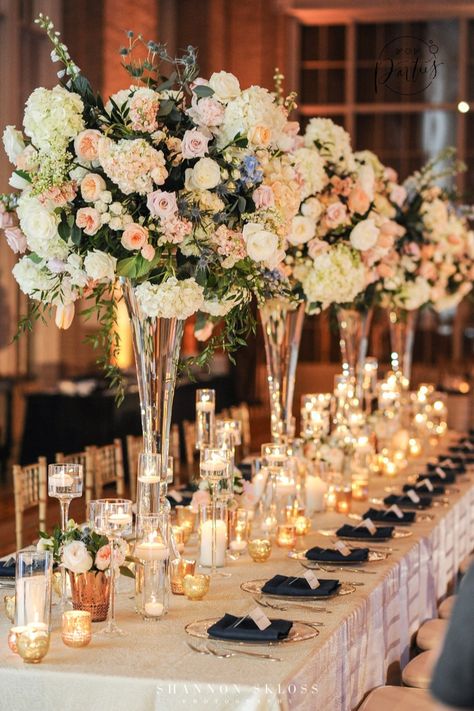 Navy and Peach Wedding, lush floral arrangements, tall floral arrangements, clear glass vases, candle lit table, head table, reception decor, peach and navy floral arrangements, navy napkin, clear gold rimed charger, #dallaswedding #dallasweddingplanner #weddingplanner #luxuryweddings Navy Floral Arrangements, Head Table Reception, Navy And Peach Wedding, Tall Vase Wedding Centerpieces, Tall Wedding Vases, Candle Lit Table, Glass Vase Wedding Centerpieces, Peach Wedding Decorations, Wedding Table Deco