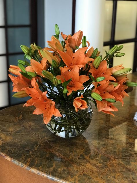 Orange lilies arranged in a glass bowl. Centerpiece, flower arrangement Tiger Lily Flower Arrangements, Lilly Floral Arrangements, Fish Bowl Flower Arrangements, Lilly Flower Arrangements, Orange Lily Flower, Asian Lilies, Tiger Lily Flowers, Hotel Flower Arrangements, Lily Centerpieces