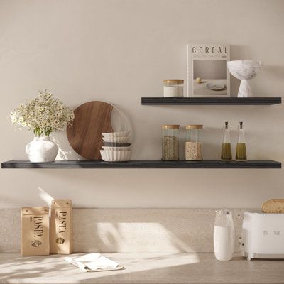 This shelf allows you to create an attractive gallery-style wall display in your home. This sleek and stylish extra-deep floating wall shelf not only elevates your décor but will let you make full use of wall storage space and display your favourite items in a creative and attractive way. Showcase your favourite album records, wall art, books, magazines, or picture frames. Use this wide shelf as a floating bookshelf, small toy organizer, photo ledge, towel shelf, or kitchen spice rack to organiz Organic Modern Living Room Shelves, Black Kitchen Floating Shelves, Black Shelf Kitchen, Black Floating Shelves Kitchen, Decorative Kitchen Shelves, Black Shelves Kitchen, Floating Shelves Dining Room Wall, Kitchen Floating Shelves Decor, Kitchen Floating Shelf