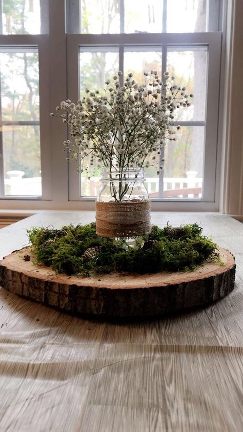 Centerpieces were made from a tree cut from the Mom to be’s yard, Moss was added on top to create a forest feel and pine cones were spray painted with gold glitter to add a pop of sparkle. The mason jars were reused from Mom and Dad to be’s wedding and babies breathe added a perfectly simple final touch to the tables. Table clothes were a white bitch print, actually being sold as Thanksgiving decor, but they worked perfectly with our theme! Tree Cut Centerpiece, Centerpieces Woodland Theme, Woodsy Baby Shower Table Centerpieces, Woodland Table Centerpieces, Woodland Baby Shower Theme Centerpieces, Forest Centerpiece Ideas, Woodland Centerpiece Ideas, Moss Table Decor, Woodsy Baby Shower Ideas