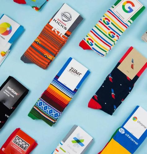 Various custom branded knitted socks on blue background. Clean Home Screen, Company Swag, Sock Designs, Swag Bags, Today's Society, Team Building Events, Sock Drawer, Promo Items, Custom Socks